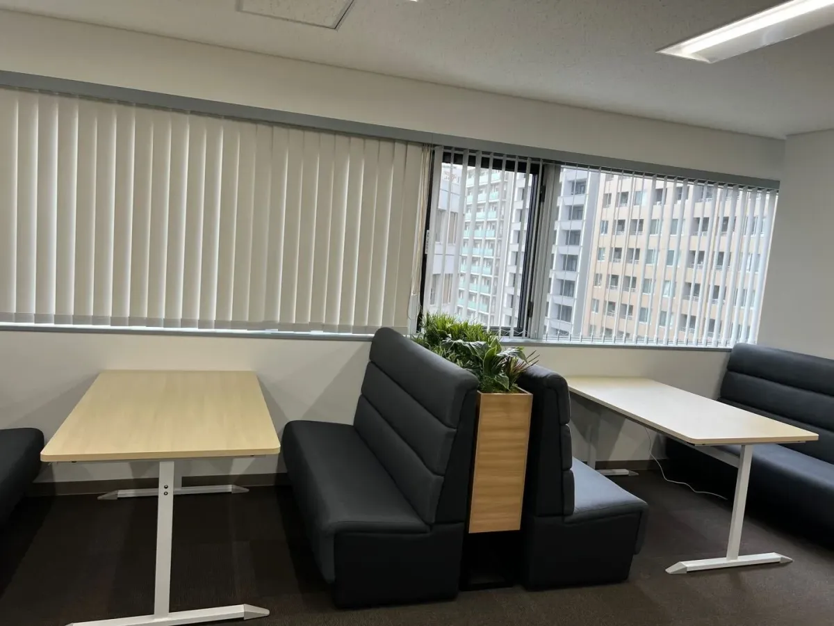 ソファ席とテーブルを備えた、本社オフィスの打ち合わせスペース